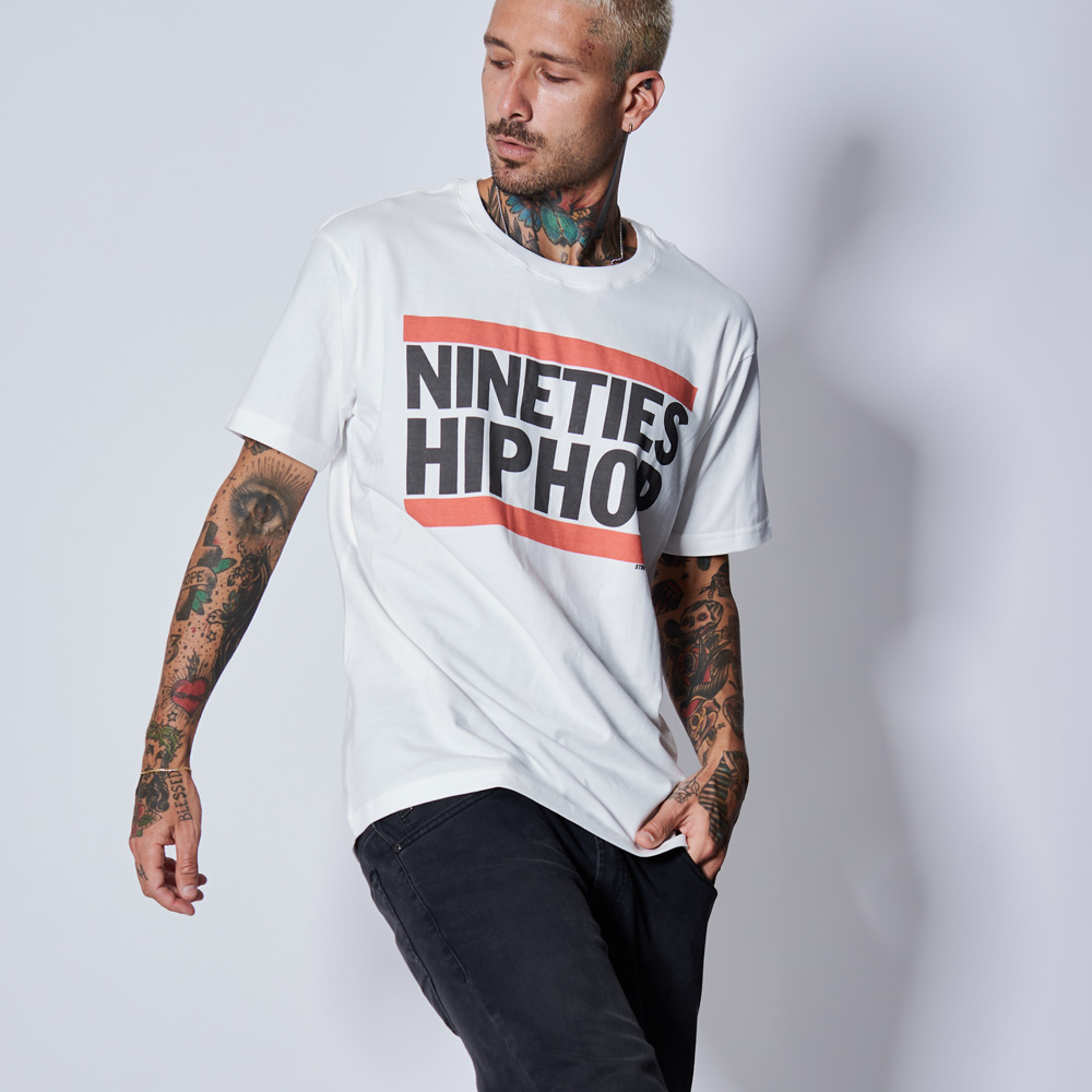 Modelo masculino de calça preta básica e camiseta branca com estampa Hip Hop, modelo exclusivo Strip Me